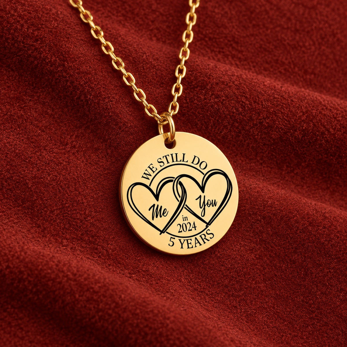 Médaille ronde dorée avec deux cœurs et inscription « 5 YEARS », sur suédine rouge sanguine.