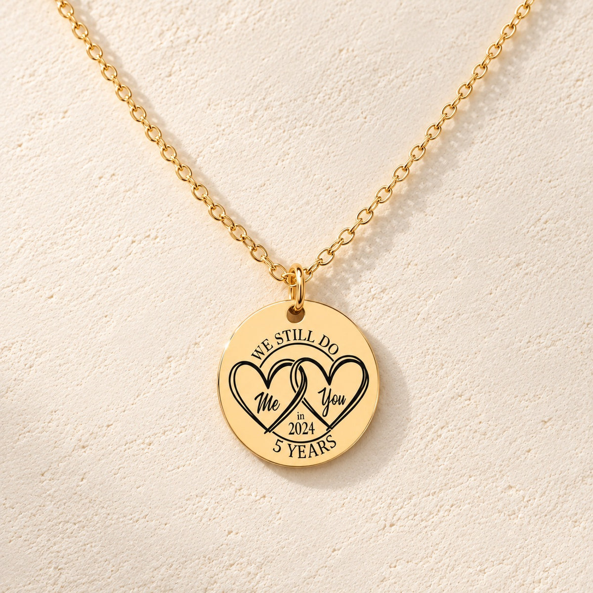 Collier Médaille Anniversaire de Mariage 5 ans doré, médaille ronde gravée avec deux cœurs et inscription « 5 YEARS », sur fond ivoire.