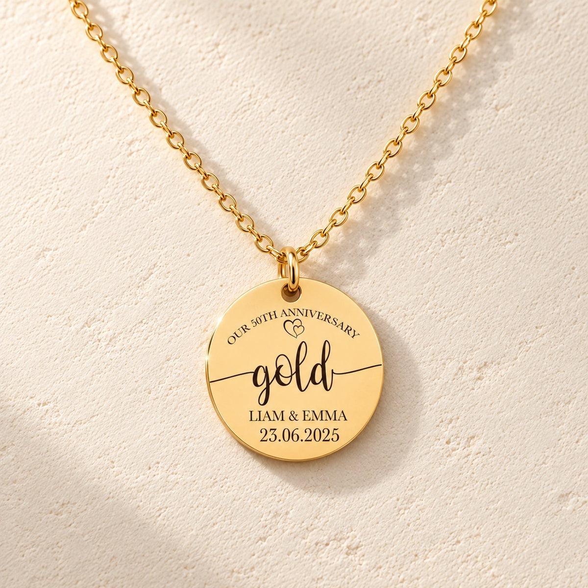 Détail de la médaille ronde dorée avec inscription « gold », prénoms Liam et Emma et date 23.06.2025.