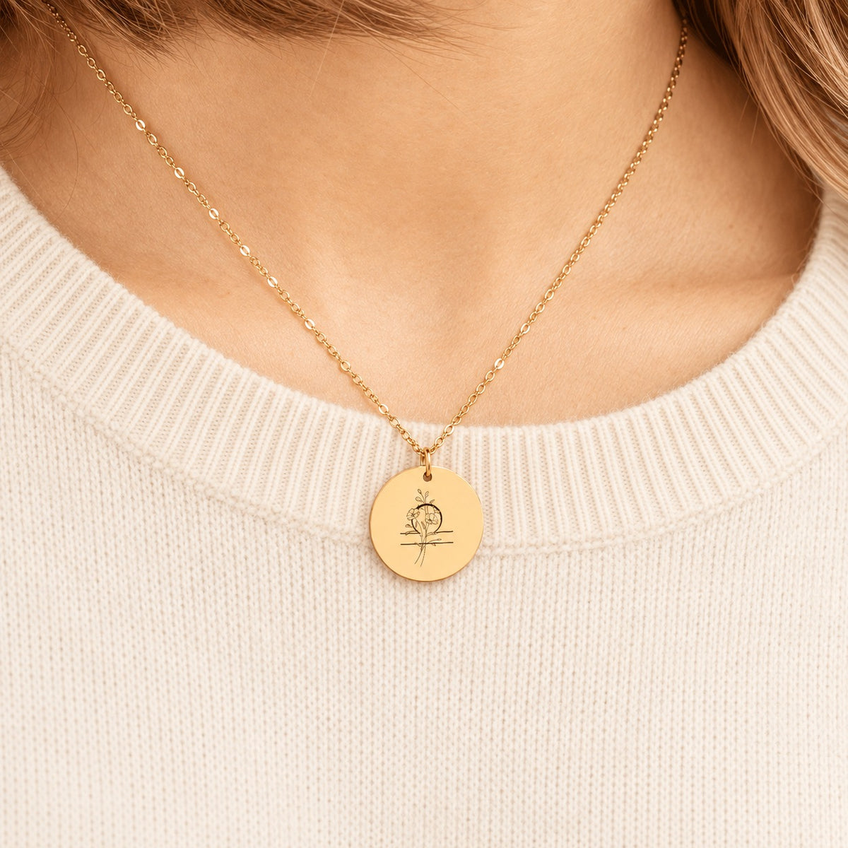 Collier médaille florale signe astrologique Balance doré porté au cou, médaille ronde gravée.