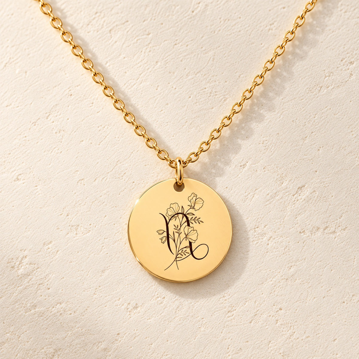 Détail de la médaille ronde dorée avec symbole du signe Capricorne et fleurs.