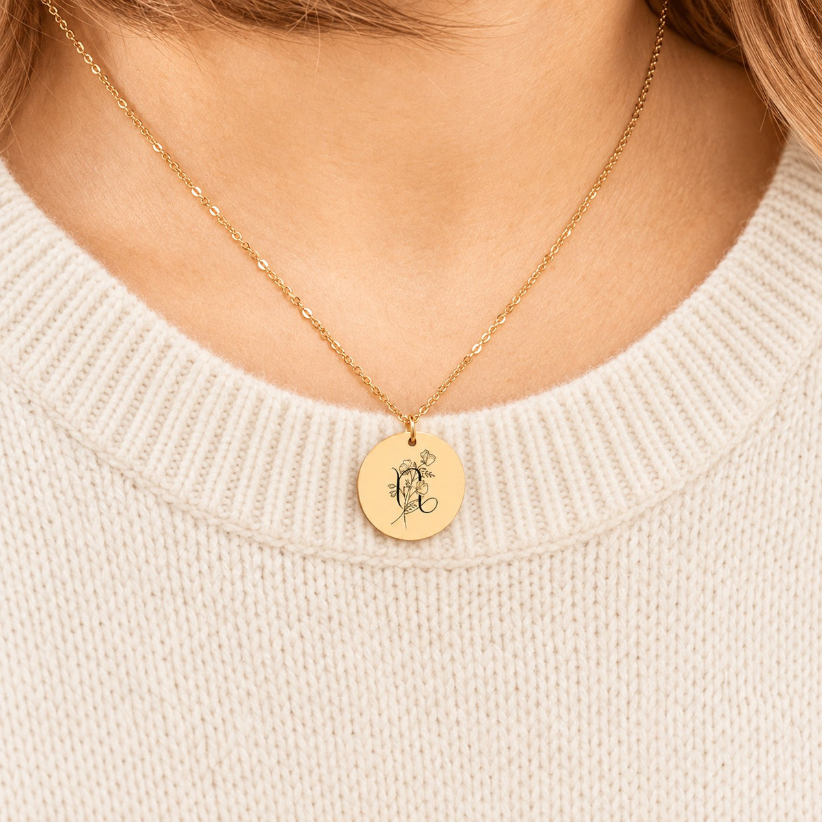 Collier médaille florale signe astrologique Capricorne doré porté au cou, médaille ronde gravée.