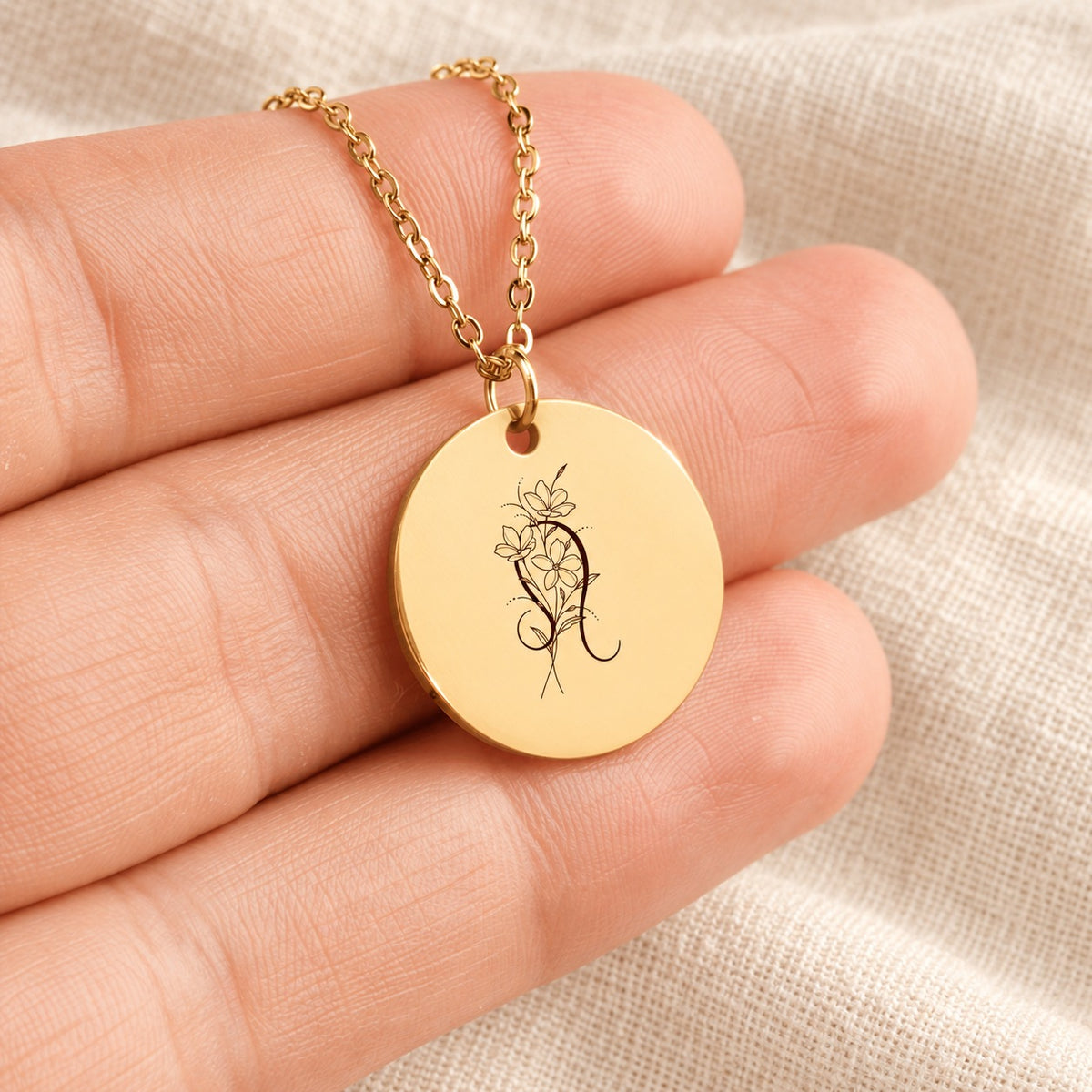 Collier médaille florale signe astrologique Lion doré tenu en main, détail de la gravure.