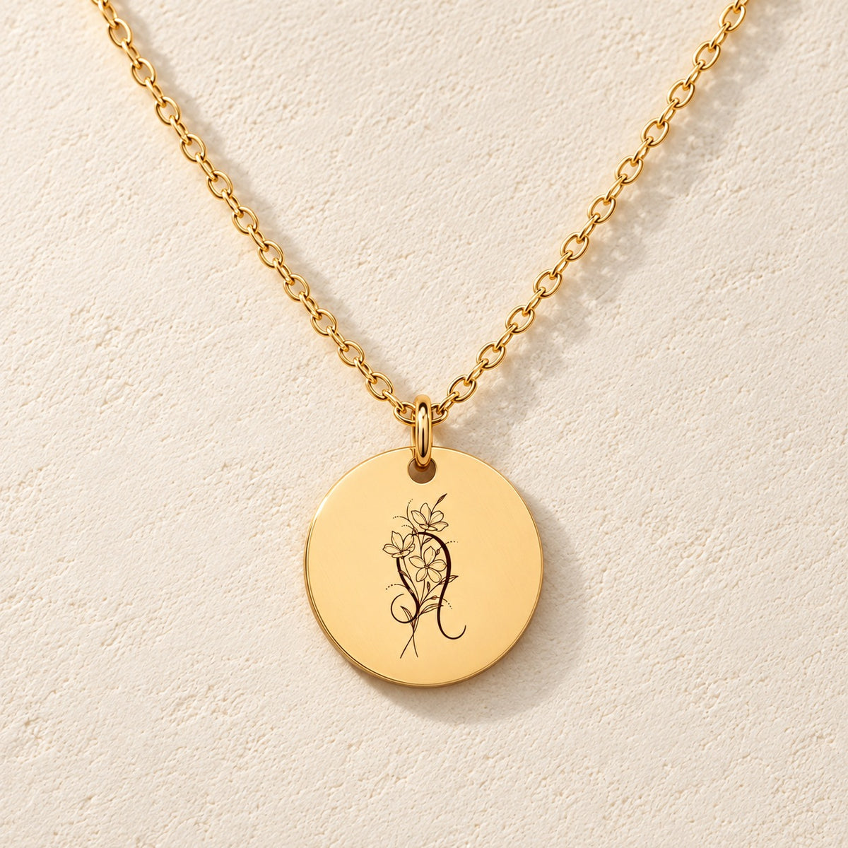 Collier médaille florale signe astrologique Lion doré, médaille ronde gravée avec symbole du signe Lion et fleurs, sur fond ivoire.