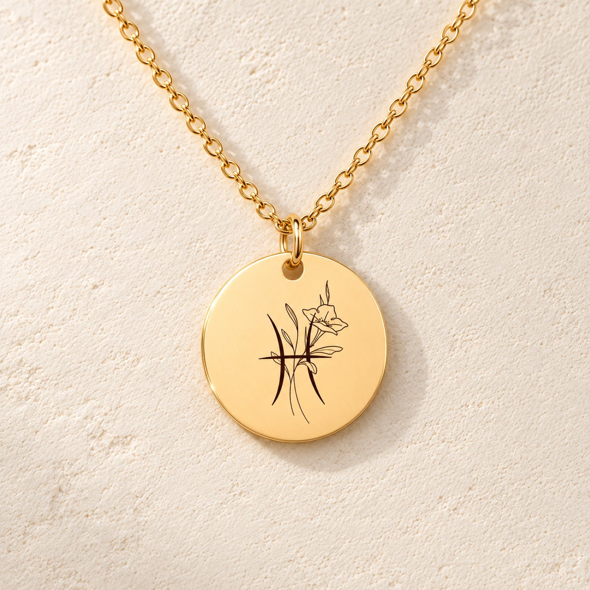 Détail de la médaille ronde dorée avec symbole du signe Poissons et fleurs.