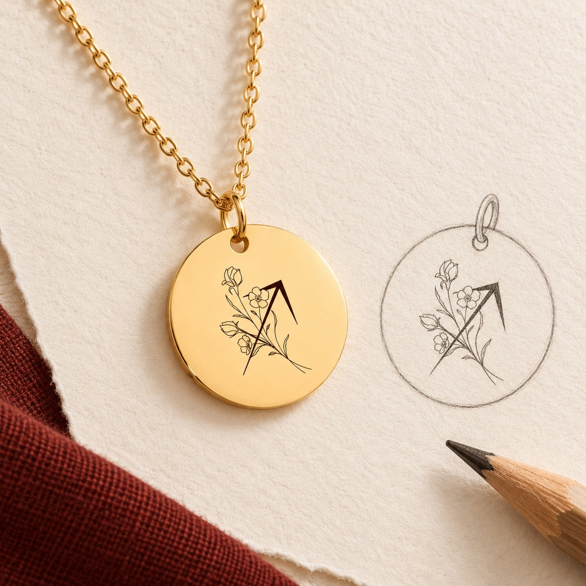 Collier médaille florale signe astrologique Sagittaire doré et étude au graphite du bijou sur papier ivoire.