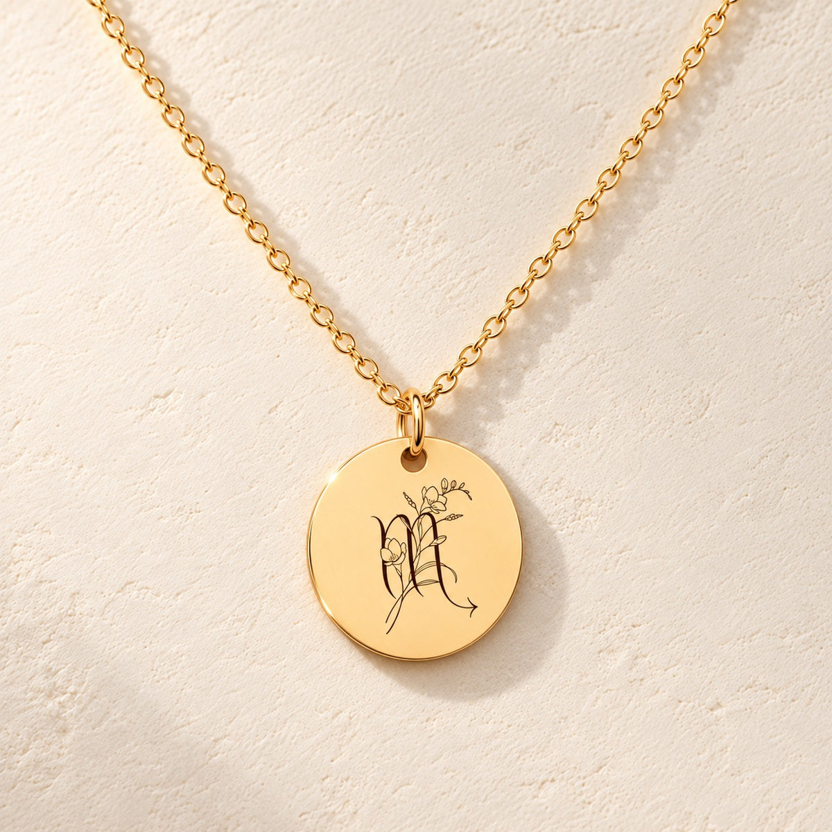 Détail de la médaille ronde dorée avec symbole du signe Scorpion et fleurs.