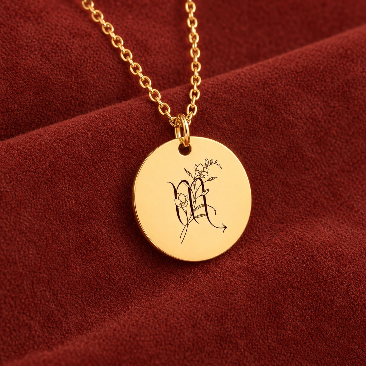 Médaille ronde dorée avec symbole du signe Scorpion et fleurs, sur suédine rouge sanguine.