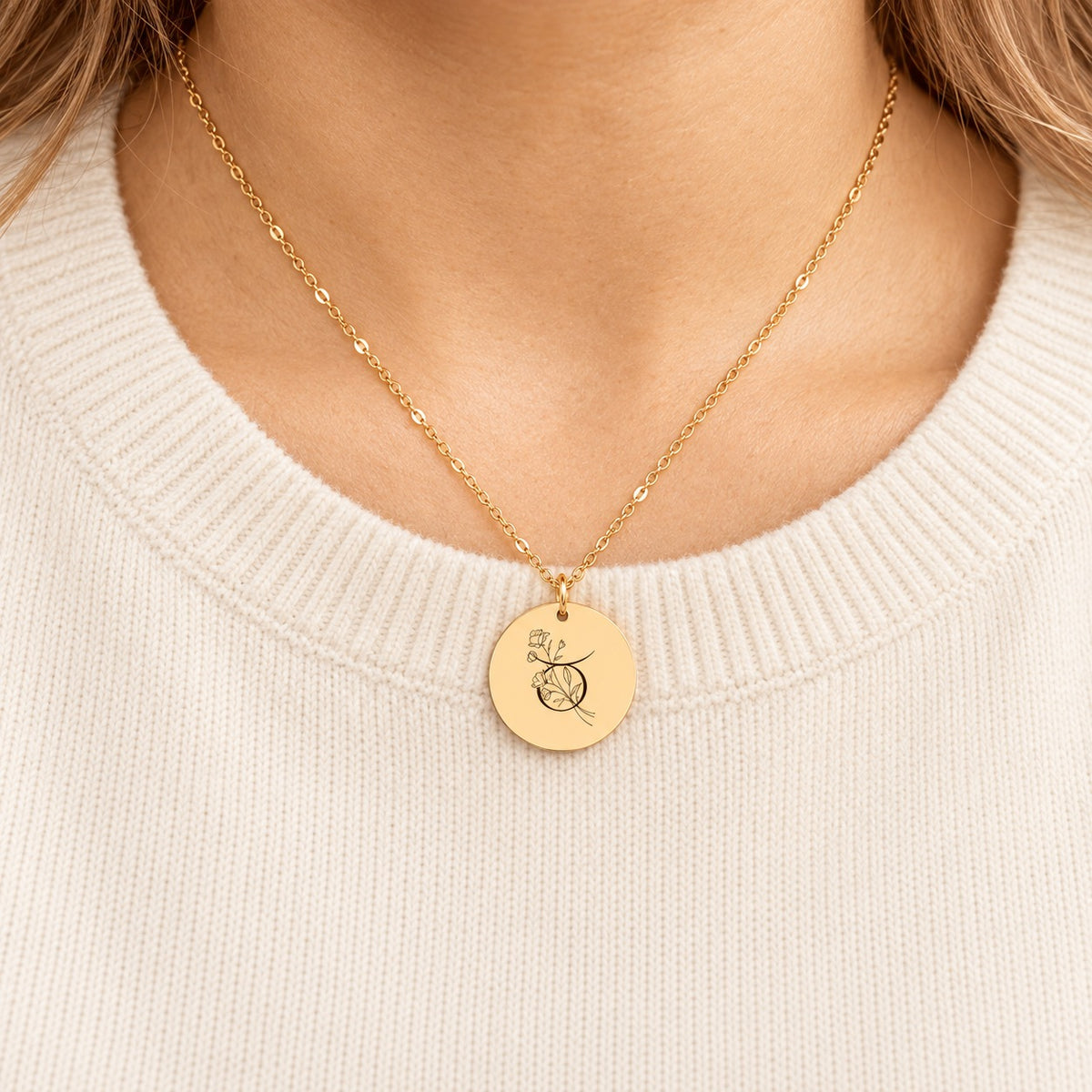 Collier médaille florale signe astrologique Taureau doré porté au cou, médaille ronde gravée.
