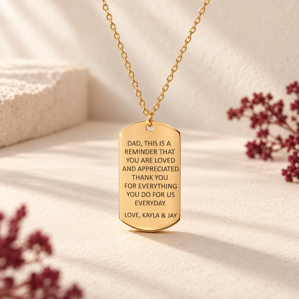 Collier Message Personnalisé doré, pendentif en forme de plaque avec message pour papa signé Kayla & Jay sur fond ivoire.