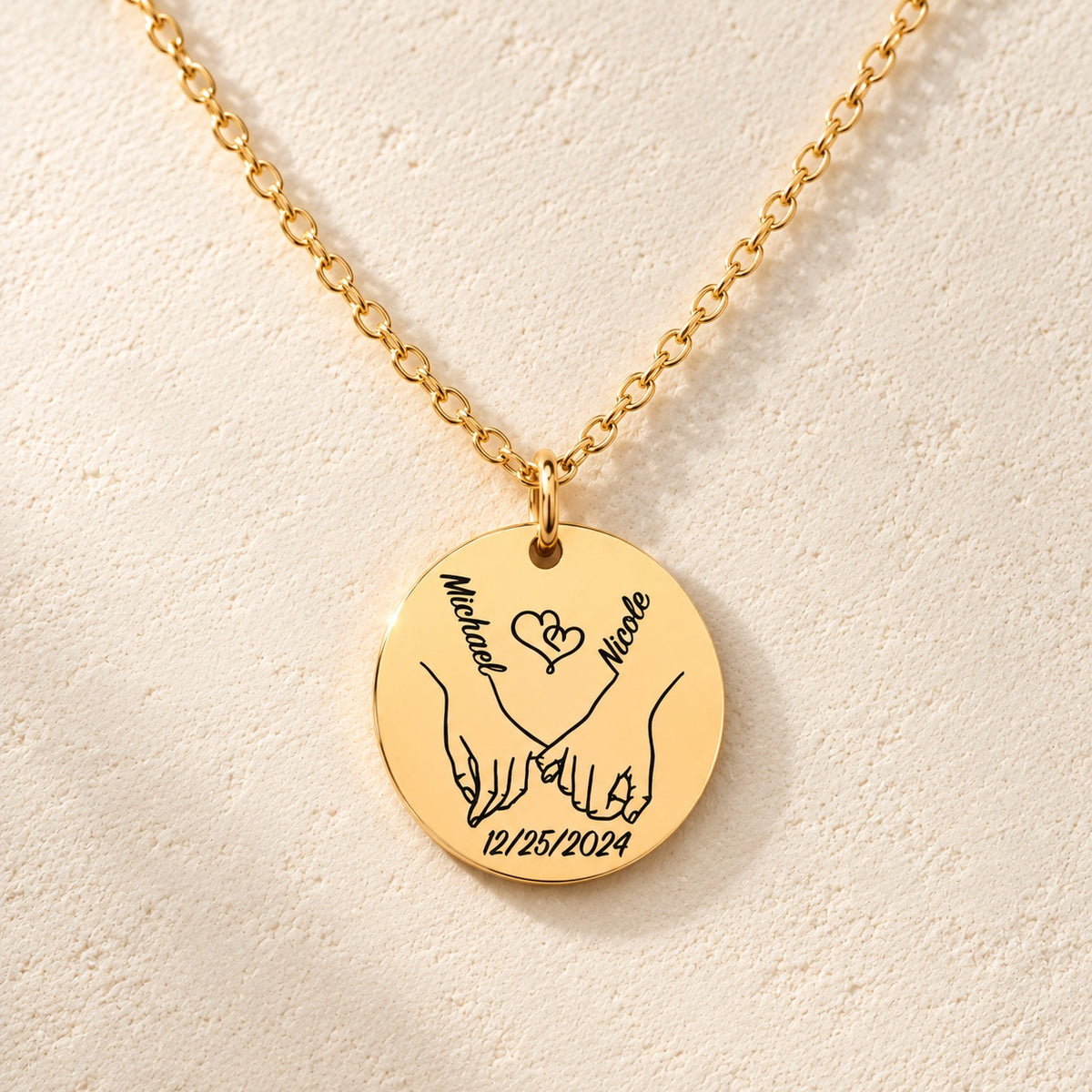 Détail de la médaille ronde dorée avec deux mains liées, prénoms Michael et Nicole et date 12/25/2024.