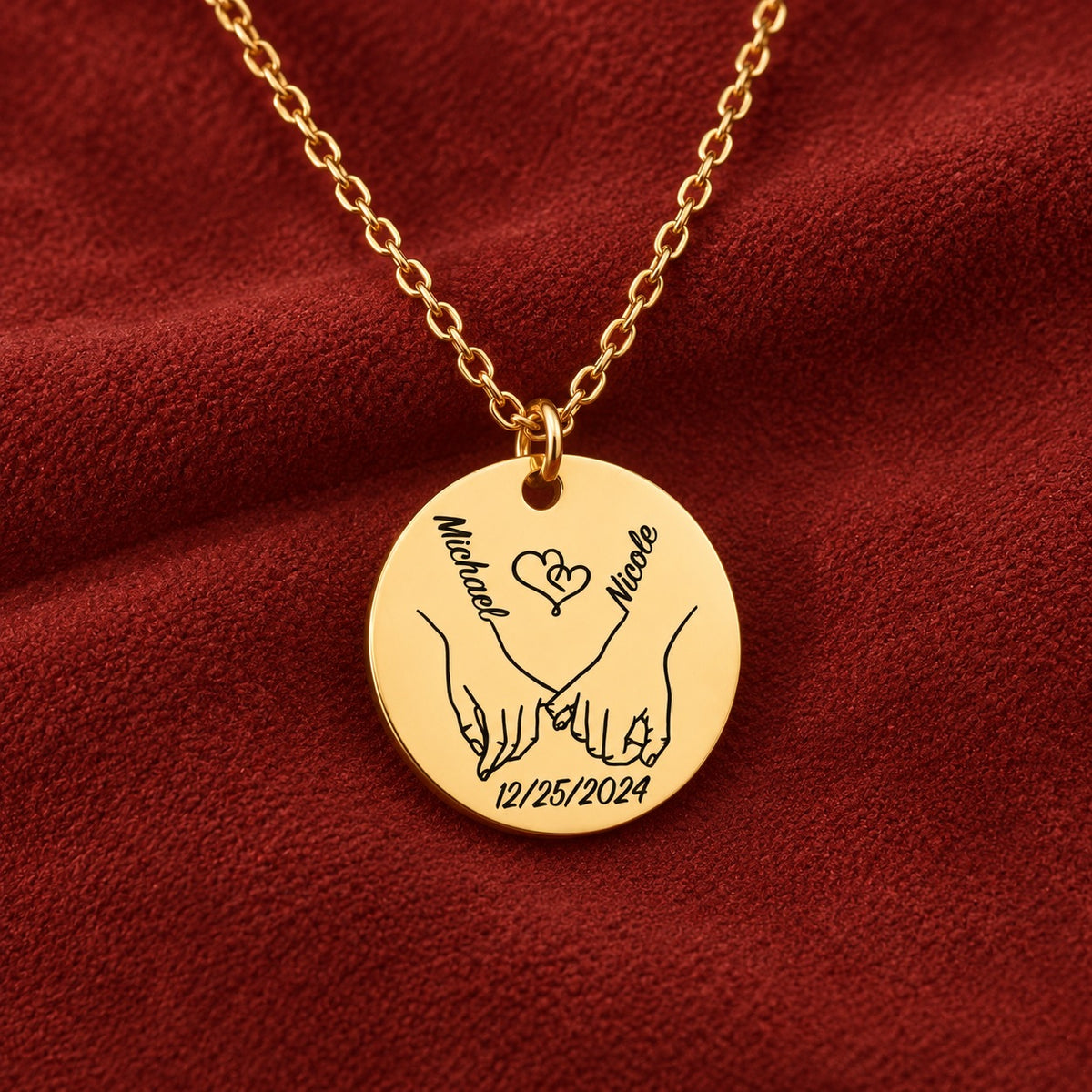 Médaille ronde dorée avec deux mains liées, prénoms Michael et Nicole et date 12/25/2024, sur suédine rouge sanguine.