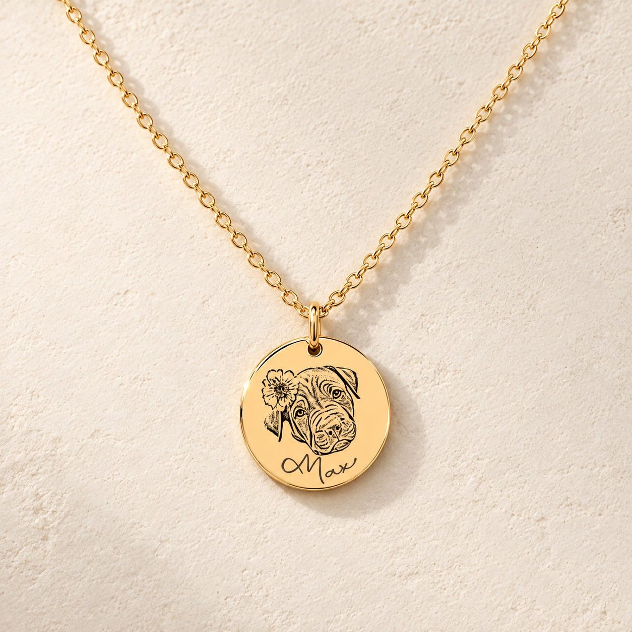 Collier portrait de chien personnalisé doré, médaille ronde gravée du portrait de Max avec une fleur et de son prénom, sur fond ivoire.