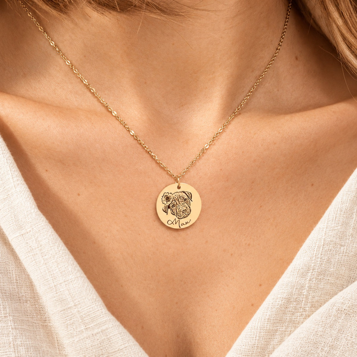 Collier portrait de chien personnalisé doré porté au cou, avec le portrait fleuri de Max et son prénom gravés sur la médaille ronde.
