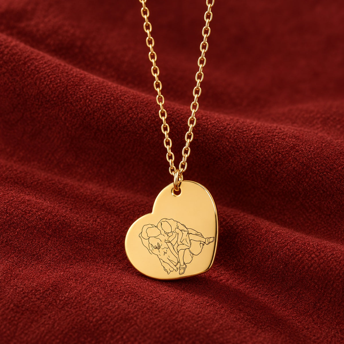 Pendentif cœur doré gravé d’un portrait en line art sur suédine rouge sanguine.