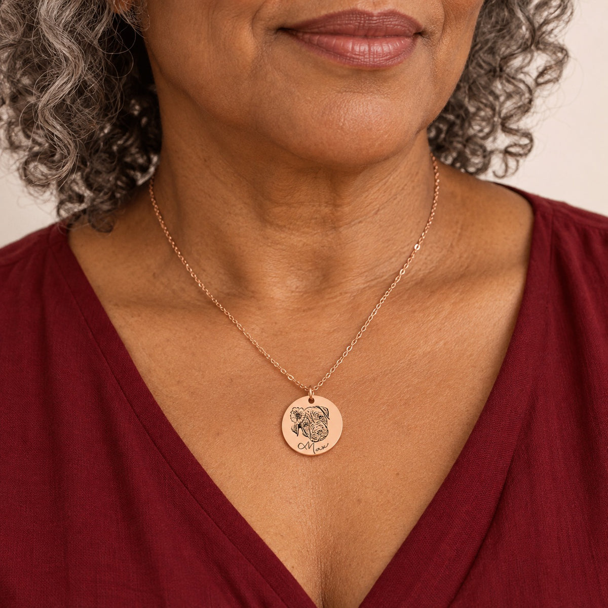 Collier portrait de chien personnalisé en finition or rose porté au cou, avec le portrait fleuri de Max et son prénom gravés sur la médaille ronde.