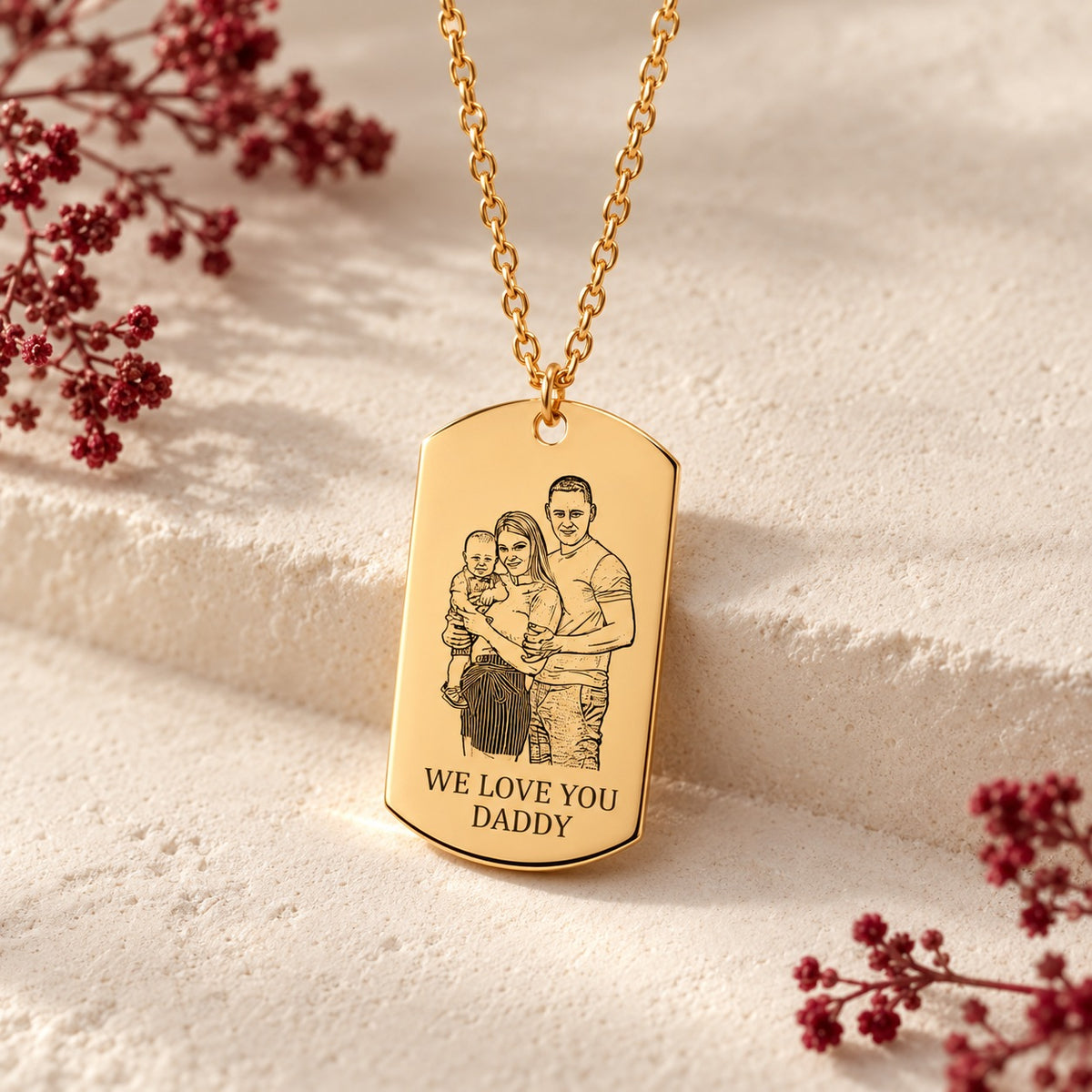 Détail du pendentif rectangulaire doré avec portrait de famille et message We love you Daddy, sur fond ivoire.