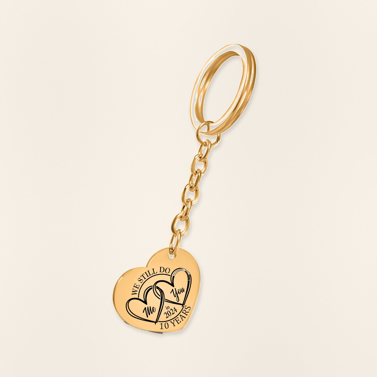 Porte-clés Coeur Anniversaire de Mariage 10 ans (noces d'étain) en finition dorée, exemple de gravure sur fond ivoire texturé.