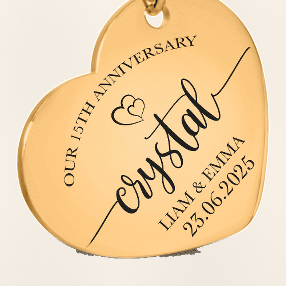 Porte-clés Coeur Anniversaire de Mariage 15 ans (noces de cristal) : gros plan du motif gravé, exemple de personnalisation en finition dorée.
