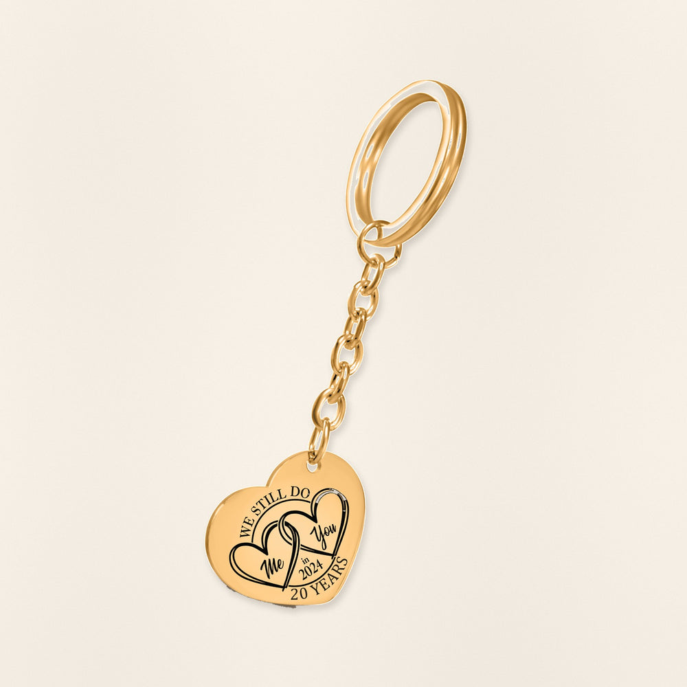 Porte-clés Coeur Anniversaire de Mariage 20 ans (noces de porcelaine) en finition dorée, exemple de gravure sur fond ivoire texturé.