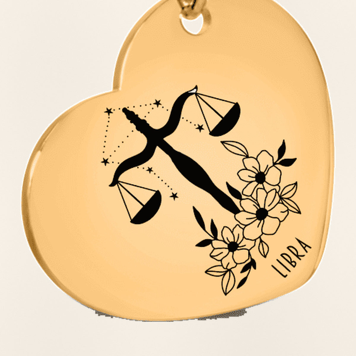 Porte-clés Coeur Signe Astrologique Balance : gros plan du motif gravé, exemple de personnalisation en finition dorée.
