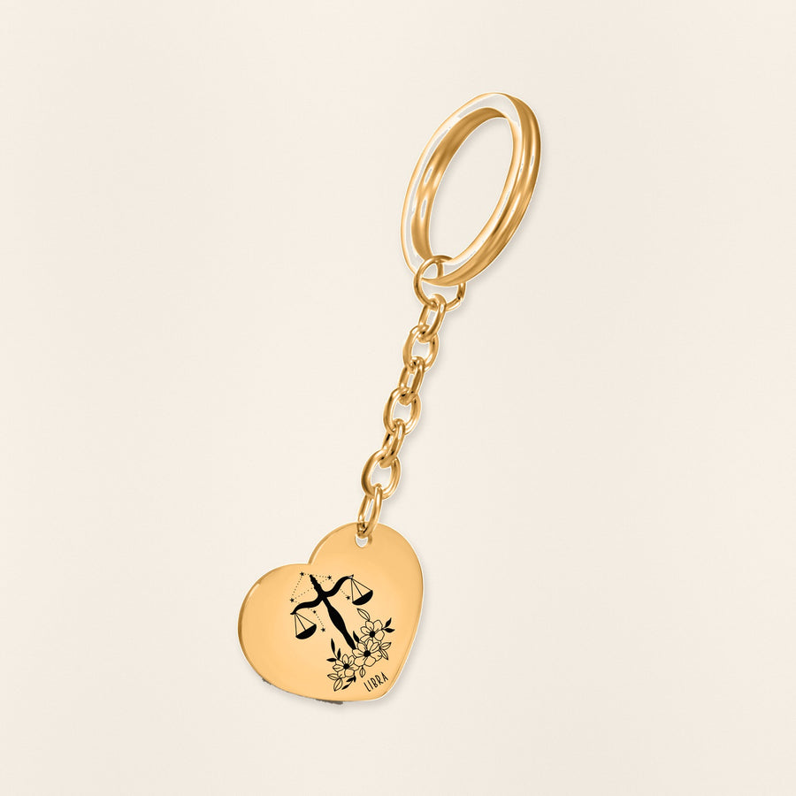Porte-clés Coeur Signe Astrologique Balance en finition dorée, exemple de gravure sur fond ivoire texturé.