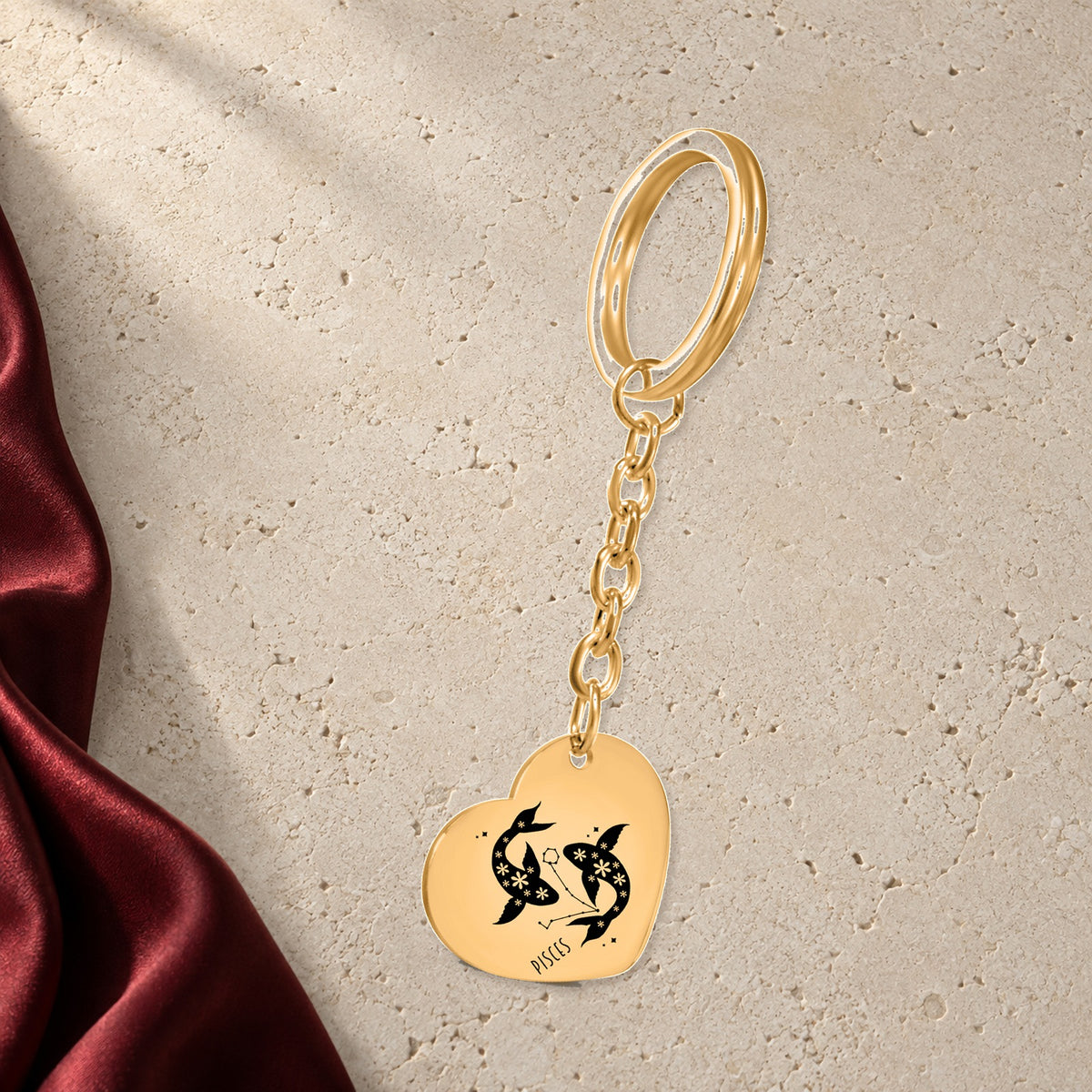 Porte-clés Coeur Signe Astrologique Poissons en finition dorée sur pierre claire, avec étoffe rouge sanguine ; exemple de personnalisation.