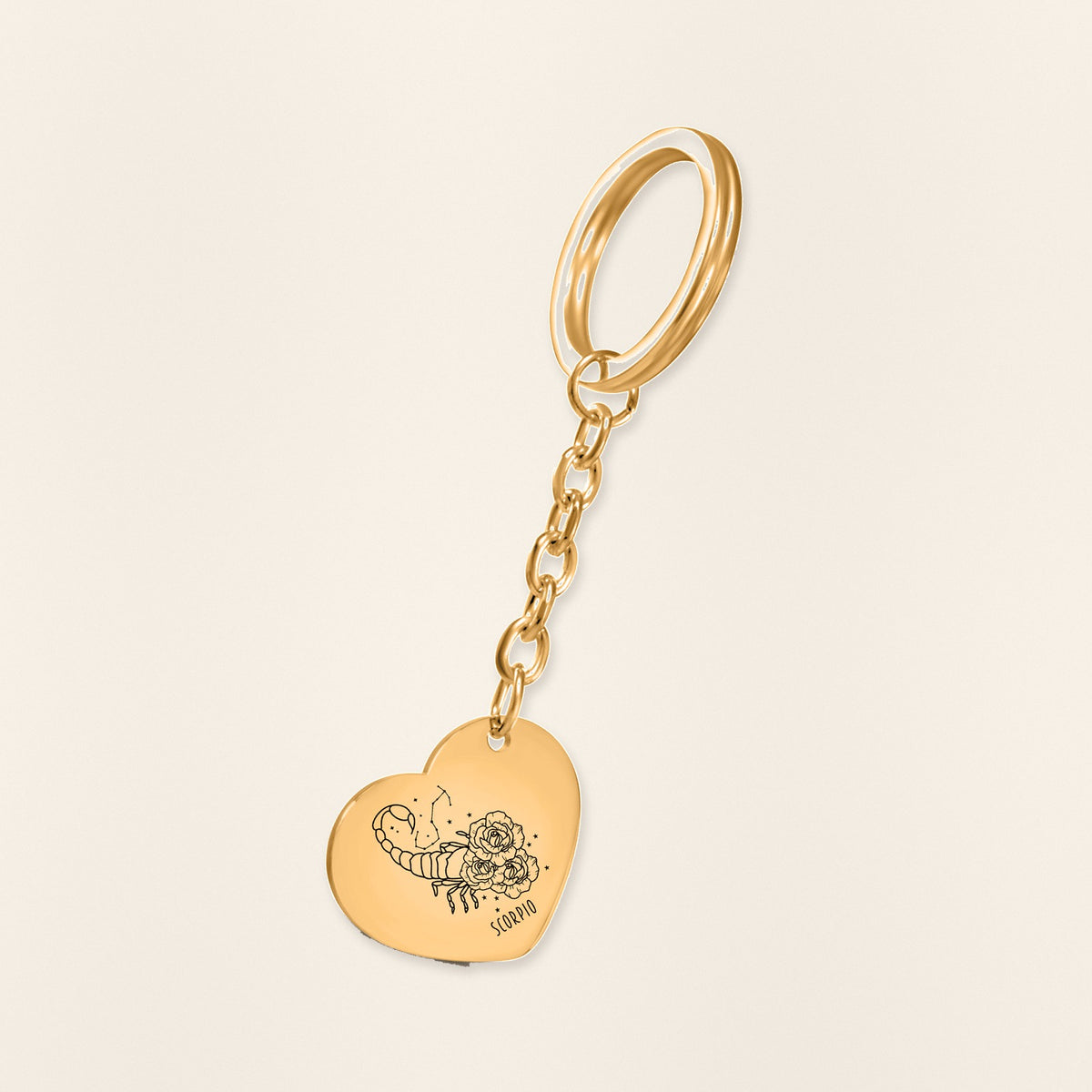 Porte-clés Coeur Signe Astrologique Scorpion en finition dorée, exemple de gravure sur fond ivoire texturé.