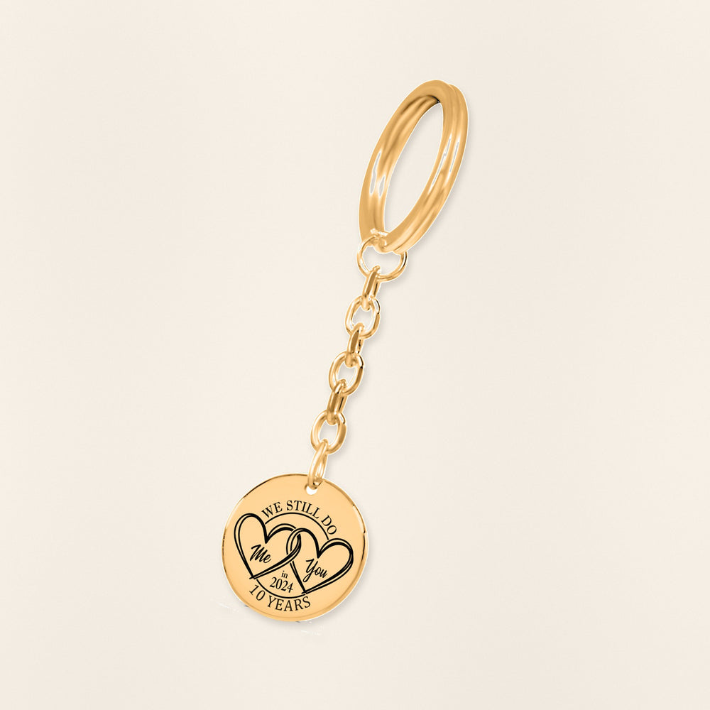 Porte-clés Médaille Anniversaire de Mariage 10 ans (noces d'étain) en finition dorée, exemple de gravure sur fond ivoire texturé.