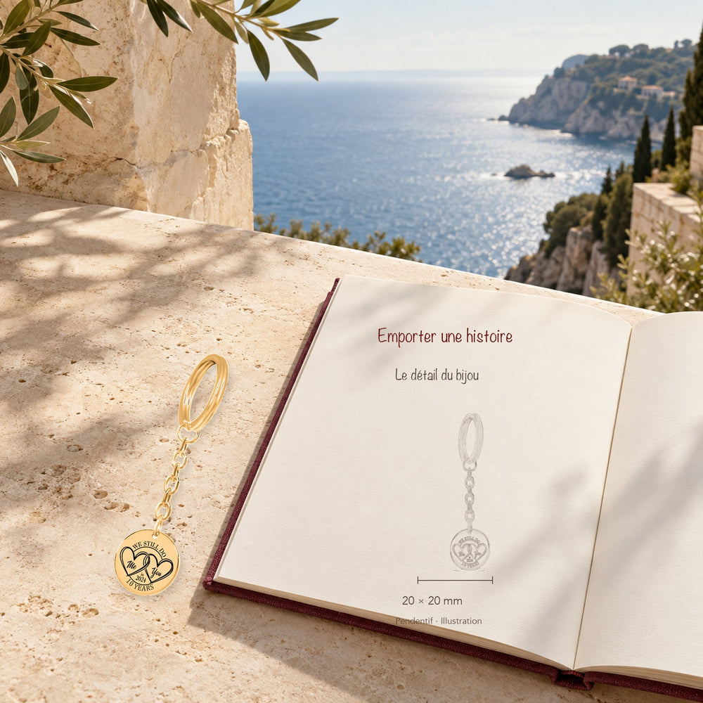 Porte-clés Médaille Anniversaire de Mariage 10 ans (noces d'étain) en finition dorée dans un décor méditerranéen, avec dessin du produit sur un carnet.