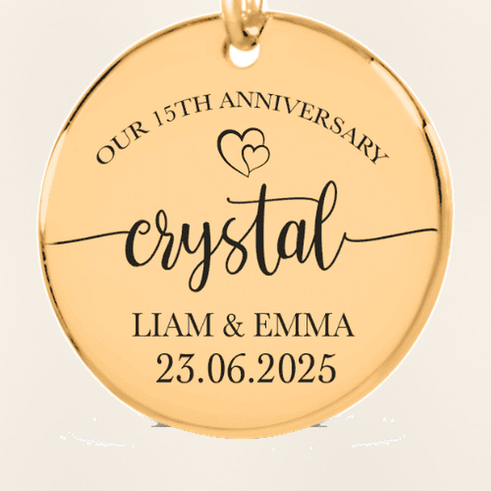 Porte-clés Médaille Anniversaire de Mariage 15 ans (noces de cristal) : gros plan du motif gravé, exemple de personnalisation en finition dorée.