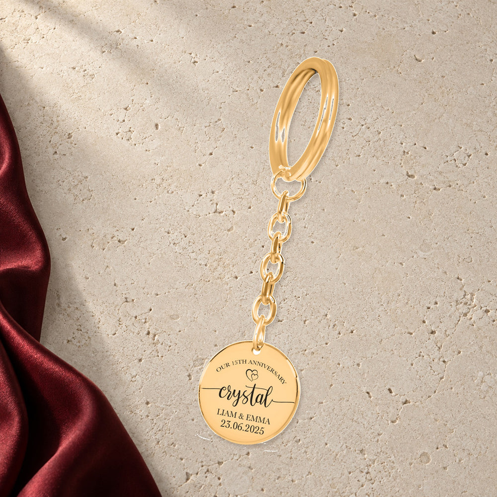 Porte-clés Médaille Anniversaire de Mariage 15 ans (noces de cristal) en finition dorée sur pierre claire, avec étoffe rouge sanguine ; exemple de personnalisation.