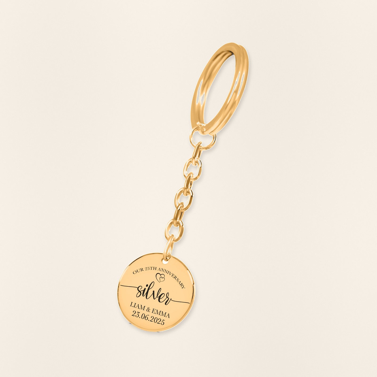 Porte-clés Médaille Anniversaire de Mariage 25 ans (noces d'argent) en finition dorée, exemple de gravure sur fond ivoire texturé.