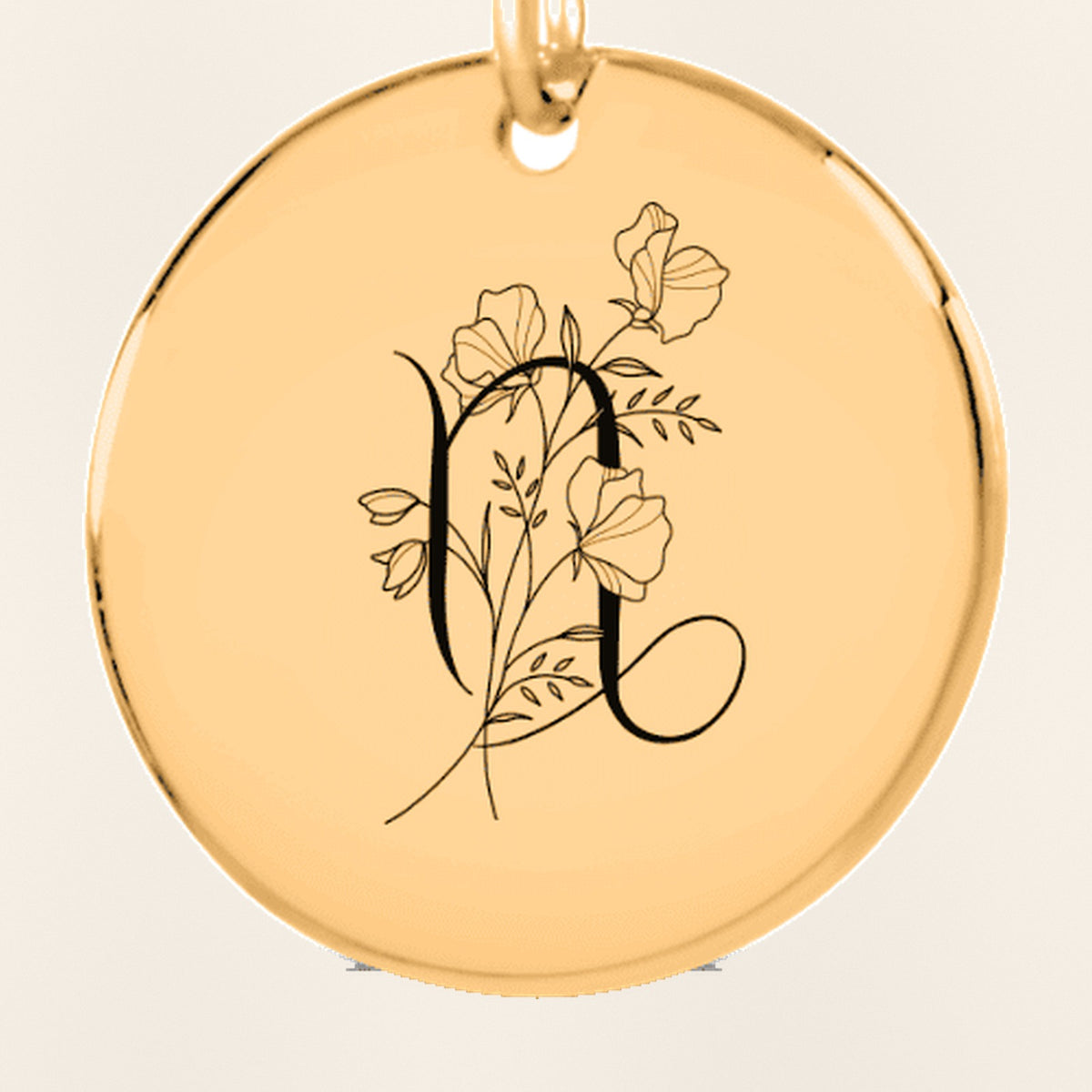 Porte-clés Médaille Florale Signe Astrologique Capricorne : gros plan du motif gravé, exemple de personnalisation en finition dorée.