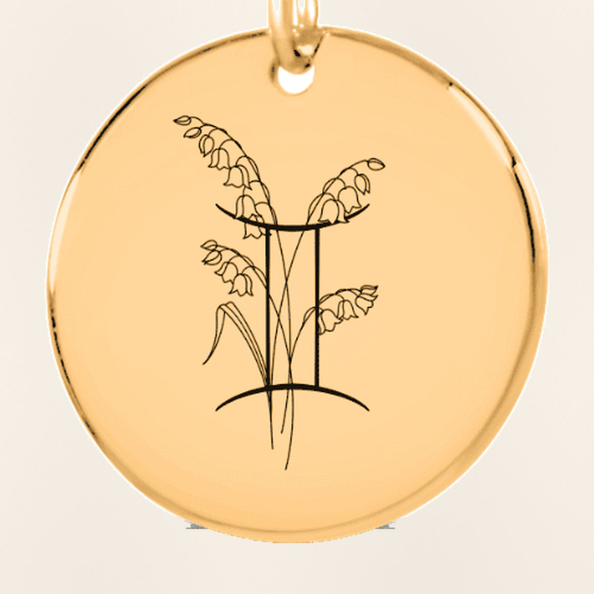 Porte-clés Médaille Florale Signe Astrologique Gémeaux : gros plan du motif gravé, exemple de personnalisation en finition dorée.