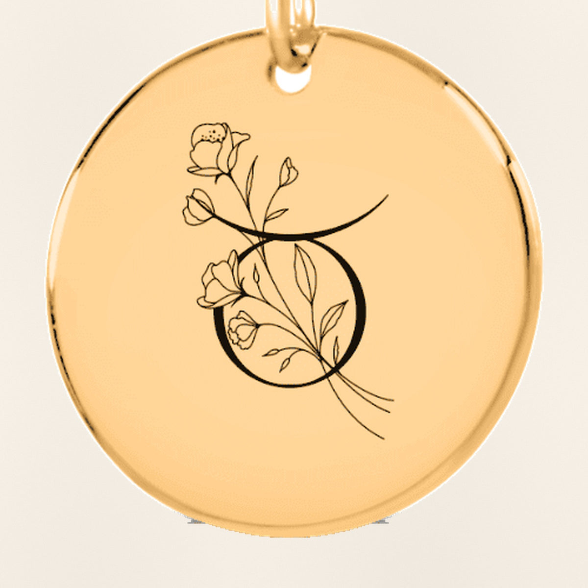 Porte-clés Médaille Florale Signe Astrologique Taureau : gros plan du motif gravé, exemple de personnalisation en finition dorée.