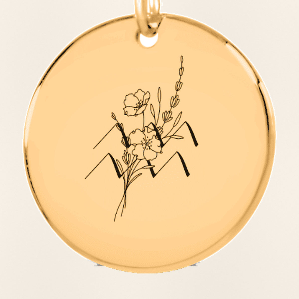 Porte-clés Médaille Florale Signe Astrologique Verseau : gros plan du motif gravé, exemple de personnalisation en finition dorée.