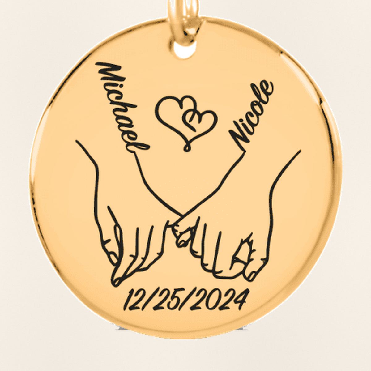 Porte-clés Médaille Notre Premier Noël Ensemble : gros plan du motif gravé, exemple de personnalisation en finition dorée.