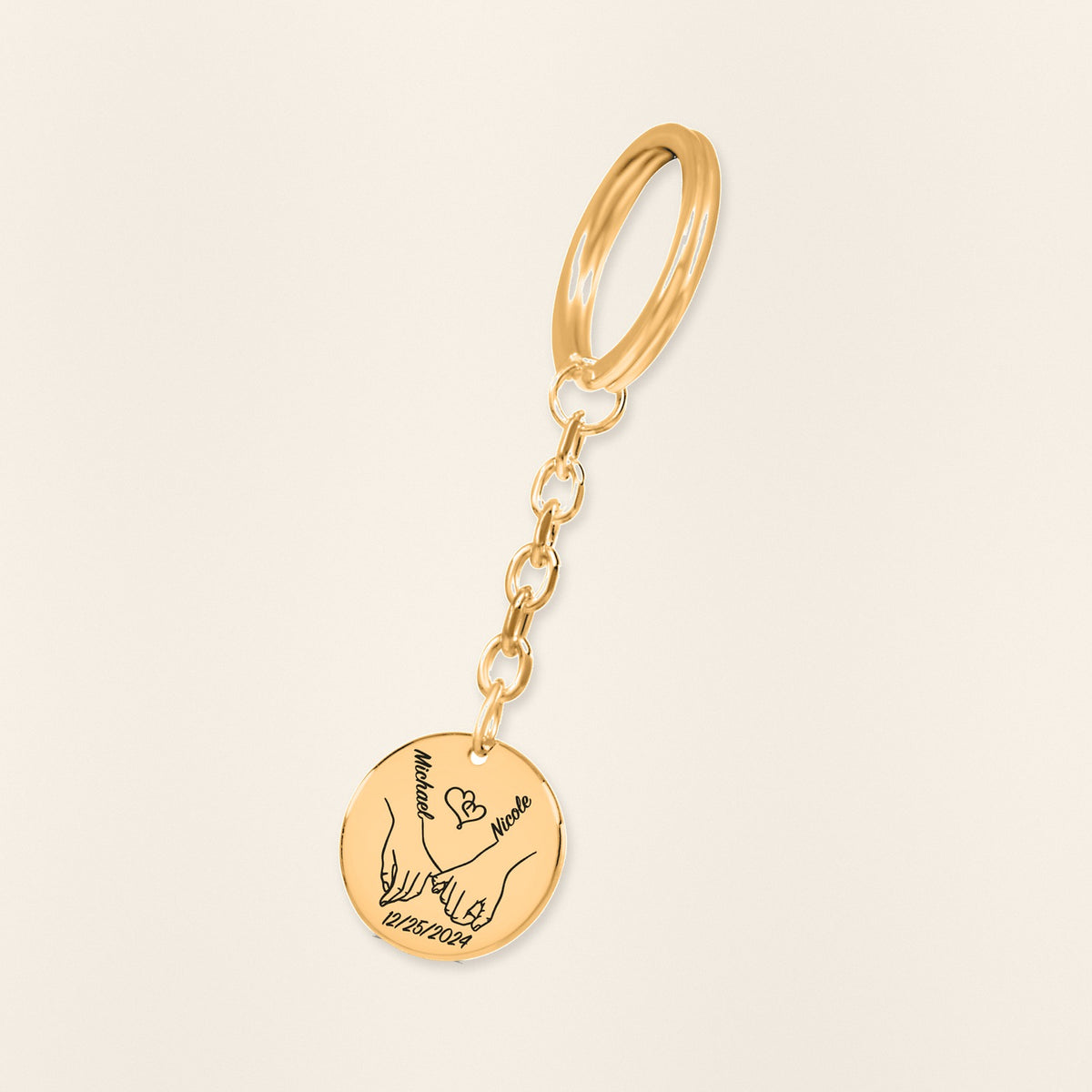 Porte-clés Médaille Notre Premier Noël Ensemble en finition dorée, exemple de gravure sur fond ivoire texturé.