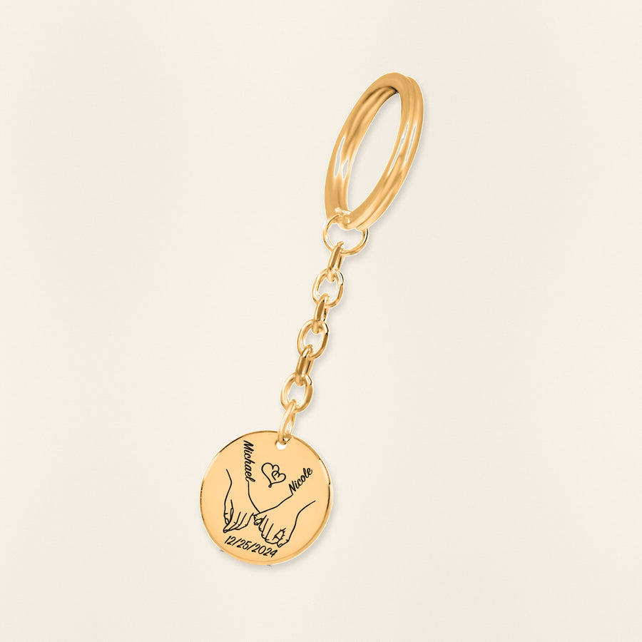 Porte-clés Médaille Notre Premier Noël Ensemble en finition dorée, exemple de gravure sur fond ivoire texturé.